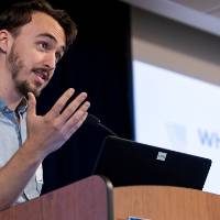 Scholar presenting research with a slideshow.